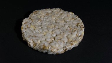 Tahıllı gevrek, çıtır pilav ve diyet ekmek. Bir yığın patlamış tahıllı çıtır ekmek. Pirinç keki siyah arkaplanda pirinç kabartması