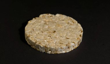 Tahıllı gevrek, çıtır pilav ve diyet ekmek. Bir yığın patlamış tahıllı çıtır ekmek. Pirinç keki siyah arkaplanda pirinç kabartması