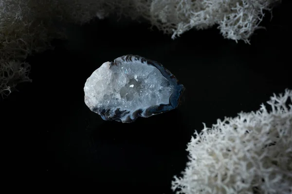 Chalcedony geode do Brasil. Pedra mineral natural sobre um fundo preto rodeado por musgo. Mineralogia, geologia, magia, pedras semipreciosas e amostras de minerais. Close-up macro foto — Fotografia de Stock