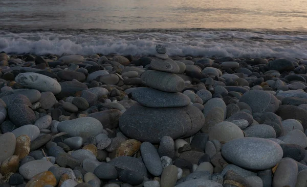 Stapel zen stenen op het strand bij zonsondergang, prachtige zeegezicht. Gemaakt van steen toren als rust balans vakantie concept. — Stockfoto