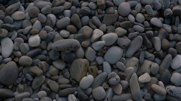 Fundo de pedras marinhas com pequenos seixos ou pedra no jardim ou à beira-mar ou em uma praia. Uma vista de perto de pedras de seixos polidas lisas arredondadas — Fotografia de Stock