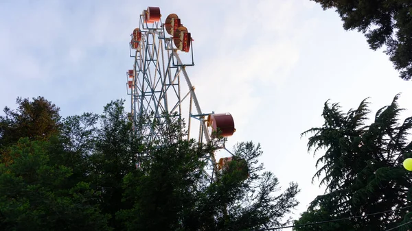 Rueda Ferris de colores brillantes contra el cielo del atardecer. Lazarevskoye, Sochi, Rusia, En la rueda la inscripción Lazarevskoe — Foto de Stock