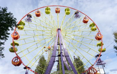 Mavi gökyüzüne karşı parlak renkli dönme dolap. Arkhangelsk, Rusya