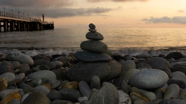 Stapel zen stenen op het strand bij zonsondergang, prachtige zeegezicht. Gemaakt van steen toren als rust balans vakantie concept. — Stockfoto