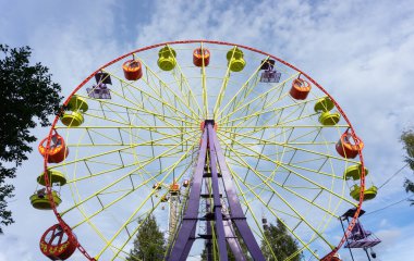 Mavi gökyüzüne karşı parlak renkli dönme dolap. Arkhangelsk, Rusya