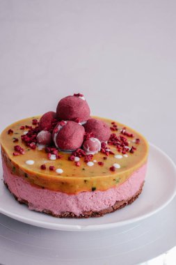 Çilekli mantarlı çiğ vejetaryen ahududu keki. Mango jöleli vejetaryen kaju kremalı cheesecake glütensiz. Laktoz şekersiz çöl beyaz tabakta. İç mekan fotoğrafı