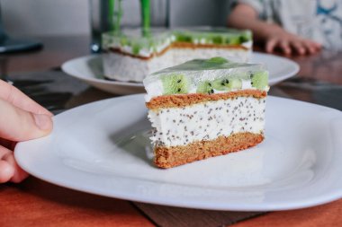 Dilimlerle süslenmiş çiğ vejetaryen kivili yeşil pasta. Hindistancevizi chia jöleli vejetaryen kaju kremalı peynirli peynirli glütensiz. Laktozsuz bayramlık organik çöl. Sağlıklı eko pasta.