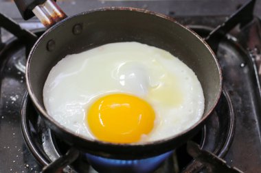 Yumurta. Kızarmış yumurta. Tavuk yumurtası. Bir kızartma tavasında kızarmış yumurta görünümü yakın. Tuzlu ve baharatlı kızarmış yumurta.