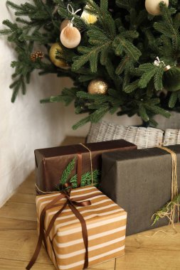 Bir sürü güzel paketlenmiş hediye süslü bir Noel ağacının altında duruyor. Ağaç süslerle süslenip tatil sezonu için mükemmel bir şenlik atmosferi yaratıyor..