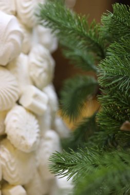 Karmaşık krem rengi dekorasyonlara yakından bakmak canlı yeşil çam dallarıyla yer paylaşmak tatil sezonu için mükemmel sıcak ve davetkar bir atmosfer yaratıyor..
