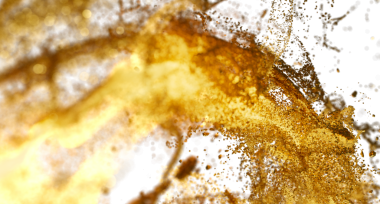 Beyaz zemin üzerinde bokeh olan soyut altın sıçrama, akan sıvı