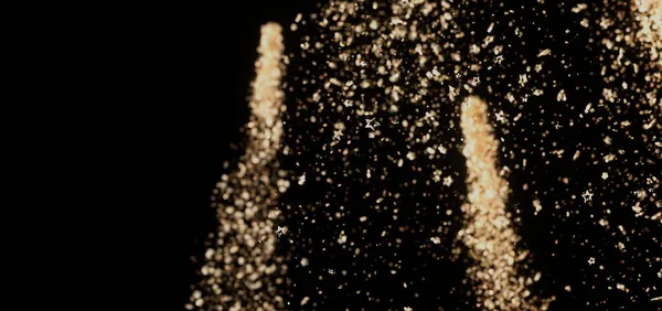 Soyut altın parıldayan yıldızlar siyah bir arkaplana çarpıyor