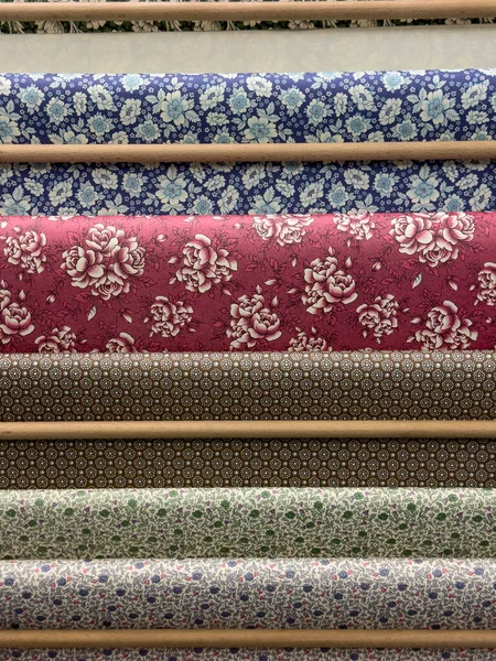 Colorful Fabric Rolls with Floral Designs on Display for Textile and Decor