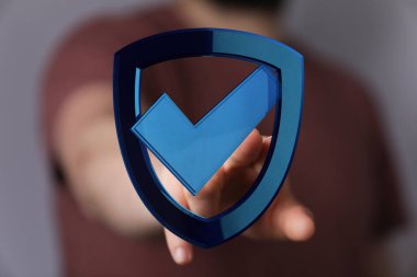 Checkmark Sembollü Dijital Kalkan Tutan Kişi: Siber Güvenlik ve Koruma Konsepti