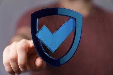 Güvenlik ve korumanın mavi kalkan simgesini gösteren kişi