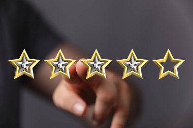 Beş yıldızlı bir resimde dört yıldızı gösteren bir el.