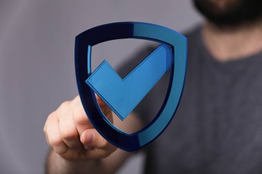 Kişi dijital kalkana işaret işareti ve internet güvenliği ile dokunuyor