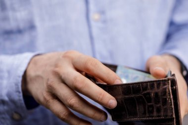 Deri cüzdan açan adam maddi yönleri ve kavramları gösteriyor