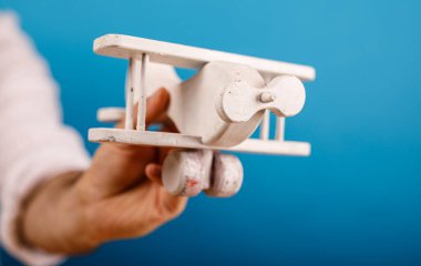 Mavi Arkaplan Karşısında Tahta Uçak Tutan Kişi