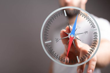 İnsanın eli dijital pusula, yön ve gelecek konseptini işaret ediyor.