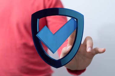 Güvenlik kalkanı sembolü ile etkileşim halinde olan kişi, teknoloji veri koruma kavramı.