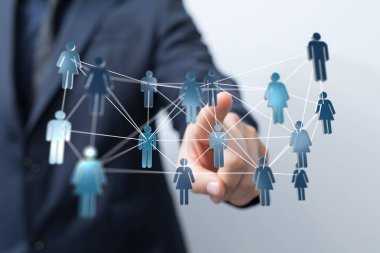 İş adamı, bağlantı ve takım çalışmasını temsil eden sanal bir insan ağıyla etkileşime geçiyor.