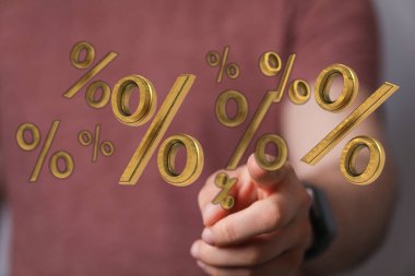 Tasarruf ve indirimleri temsil eden altın yüzde sembollerine işaret ediliyor