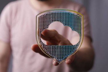 Adam elinde bulut veri güvenlik kalkanı konseptini sunuyor.