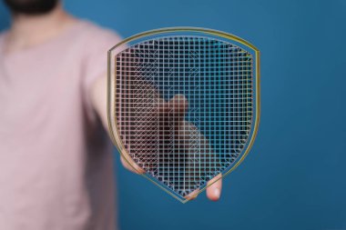 Adamın elinde siber güvenlik ve güvenliği simgeleyen dijital veri kalkanı var