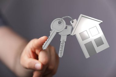 Bir ev sembolünün anahtarına sahip olan kişi ev sahipliği ve güvenliği temsil ediyor.