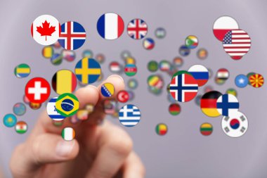 Küresel bağlantı ve birliği temsil eden çeşitli ulusların bayraklarına dokunmak