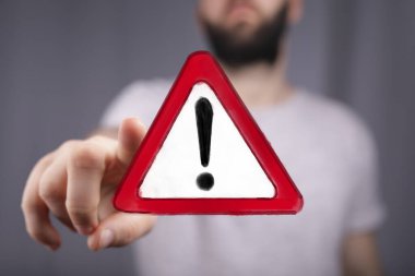 Kırmızı Uyarı İşareti taşıyan Kırmızı Uyarı İşareti Tehlike ve Uyanışı simgeliyor