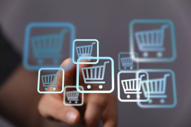 Çevrimiçi alışveriş konsepti dijital alışveriş arabası simgesine elle basılıyor.