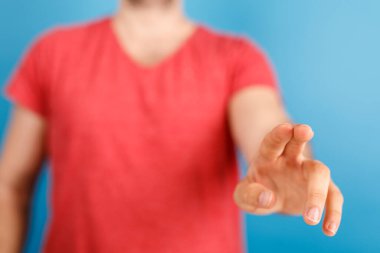 İnsan eli mavi bir arkaplanın önünde ileri doğru işaret ediyor.