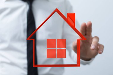 İşadamı Kırmızı Ev Simgesini Göstererek Gayrimenkul Yatırımını ve Sahipliğini Sembolize Ediyor