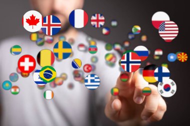 Dünya konseptini temsil eden bir ele doğru dalgalanan uluslararası bayraklar