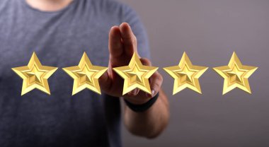 İnsanın eli beş yıldızlı geri bildirim konseptine dokunuyor.