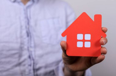 Kırmızı Kağıt Evi Modeli Tutan Kişi