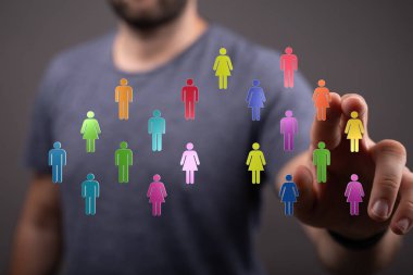 Ağ konseptini temsil eden renkli insan simgelerine dokunan adam