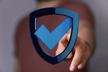 İşaretli mavi bir kalkan simgesini gösteren bir adam, dijital güvenlik