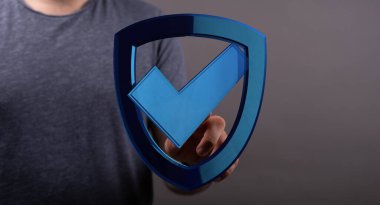 Veri güvenliği kavramı olarak işaretli mavi bir kalkan tutan adam.