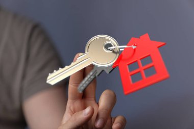 Ev sahipliğinin kırmızı bir sembolü olan el ele tutuşma anahtarları.