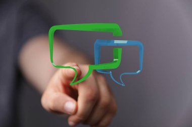 İletişimi temsil eden dijital konuşma baloncuklarına işaret eden bir el