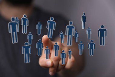 Bağlantı ve takım çalışmasını temsil eden dijital insan simgelerini gösteren adam.