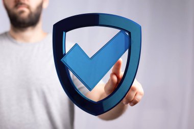 Adam işaret kalkanına dokunuyor, güvenliği ve korumayı simgeliyor.