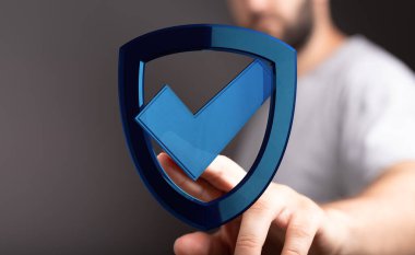 İşaretli bir 3 boyutlu kalkan tutan adam, siber güvenlik kavramı