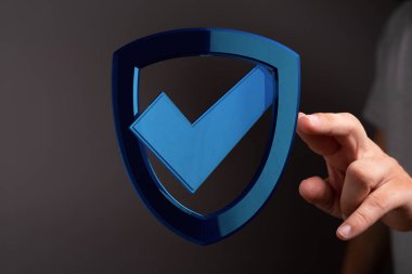 Güvenlik, güven ve koruma kavramına sahip bir kalkanı elinde tutmak