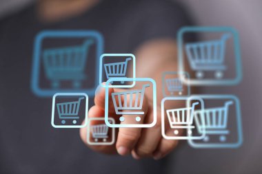 Alışveriş arabası simgelerine, çevrimiçi ticarete ve dijital alışverişe dokunan adam