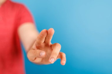 Mavi arkaplanı işaret eden, dokunan ya da bastıran ellere yakın plan