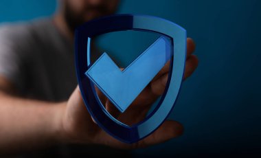 Veri koruma kavramı için kontrol işaretli mavi kalkanı tutan adam